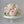 Load image into Gallery viewer, “Elegant floral cake covered with large buttercream roses and peonies in pastel shades of pink, cream, and yellow with green leaves.”