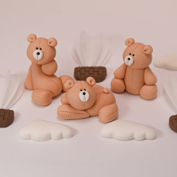 Handmade fondant teddy bears, hot air balloons, and clouds arranged neatly for cake decoration.