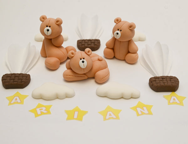 Edible fondant cake toppers featuring three teddy bears, hot air balloons, clouds, and yellow stars spelling the name “ARIANA”.