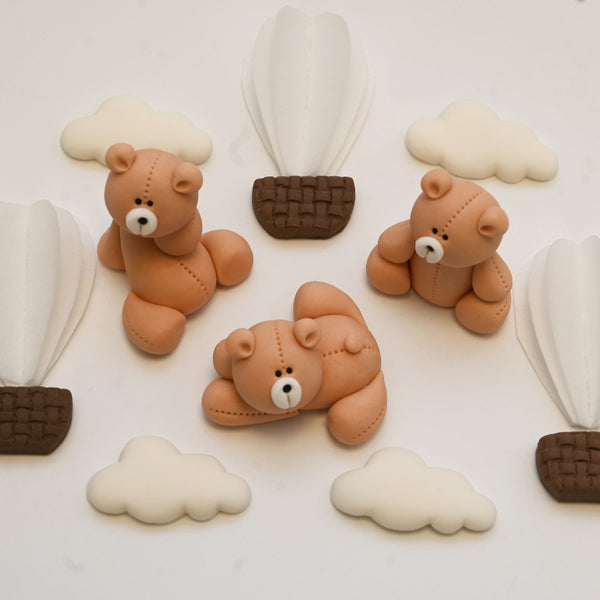 Set of edible fondant decorations including three teddy bears, fluffy white clouds, and brown hot air balloons with white sails.