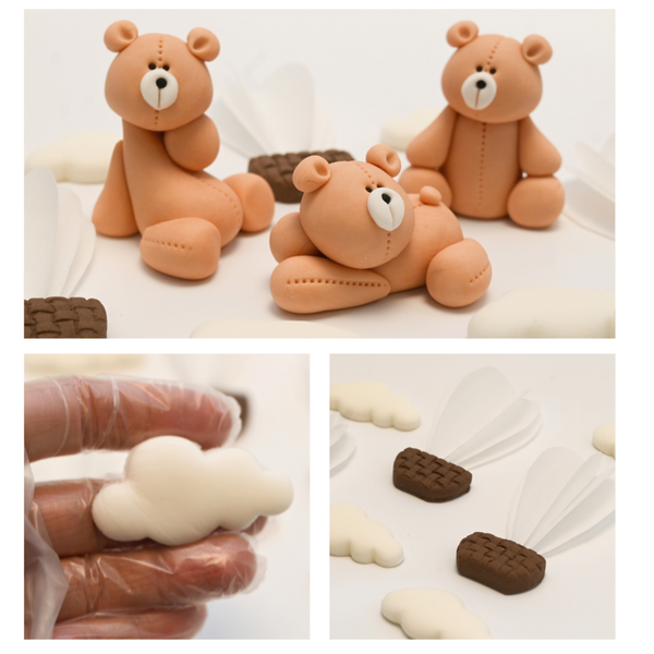 Close-up of handcrafted fondant teddy bear, cloud, and hot air balloon cake toppers held in a gloved hand.