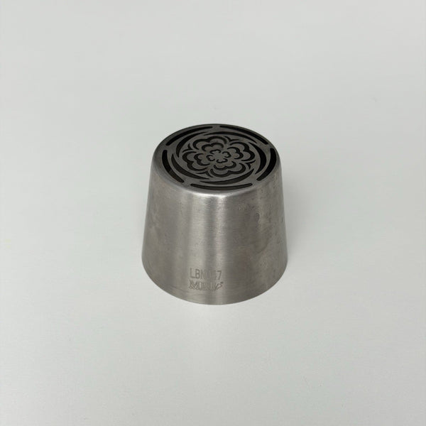 metallic tool with decorative top on a light gray background
