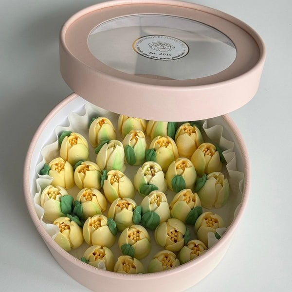 Pink box with yellow tulips on a light gray background
