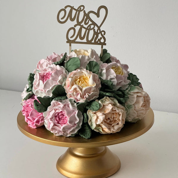 handmade marshmallow flower bouquet cake with pastel flowers on gold cake stand with mr and mrs topper
