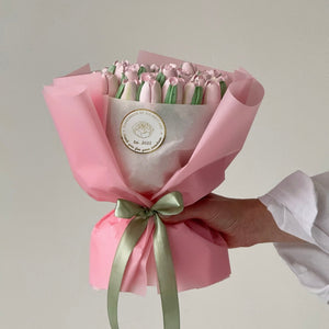 handmade marshmallow flower bouquet with pastel pink tulips wrapped in pink paper with green ribbon