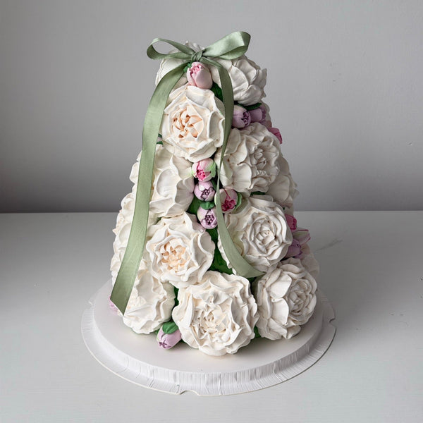 Marshmallow Christmas tree decorated with white edible flowers and green bow