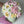 Load image into Gallery viewer, handmade marshmallow flower bouquet cake with pink, white and yellow blooms and green leaves arranged in a pastel green box, held in gloved hands
