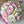 Load image into Gallery viewer, close-up of a handmade marshmallow flower bouquet with pink, white and yellow blooms and green leaves held in gloved hands
