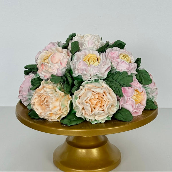 bouquet style marshmallow flower cake displayed on a gold stand