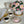 Load image into Gallery viewer, handmade marshmallow flower cake in a pastel striped box displayed with elegant vintage china teapot, teacups filled with tea, gold cake utensils, and a marshmallow flower on a dessert plate
