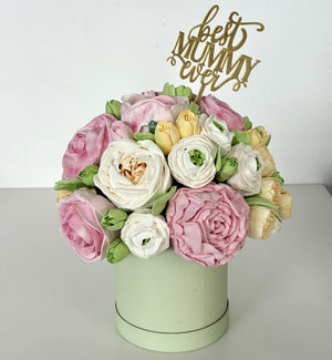 handmade marshmallow flower bouquet cake with pink, white and yellow flowers in a pastel green box topped with a gold “best mummy ever” cake topper