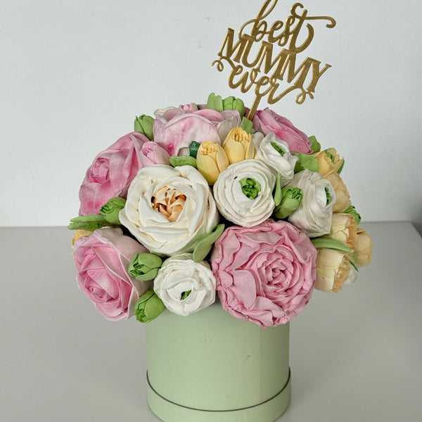 pastel marshmallow flower arrangement cake in a light green box with a gold best mummy ever topper