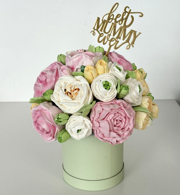 handmade marshmallow flower bouquet cake with pink, white and yellow flowers in a pastel green box topped with a gold “best mummy ever” cake topper